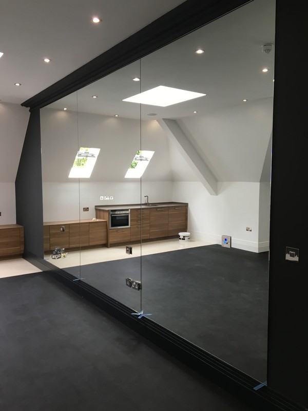 Frameless glass partition in loft conversion by Holland Park glaziers