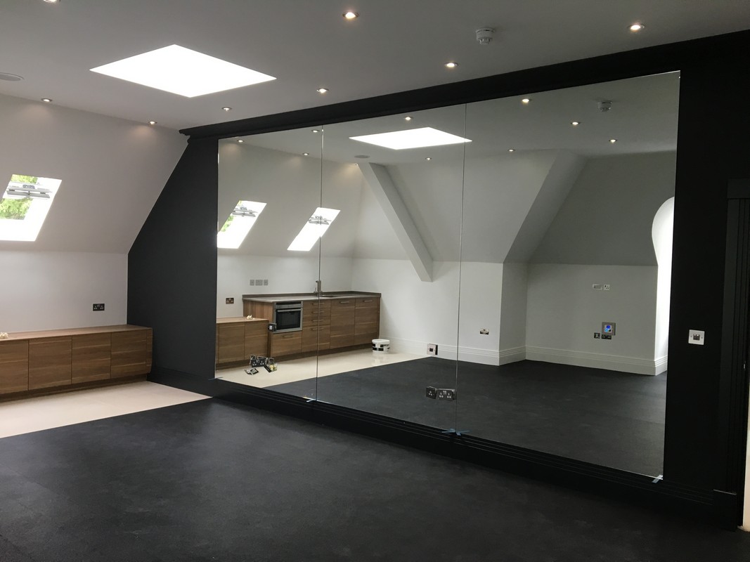 Frameless glass wall dividing loft conversion in Holland Park